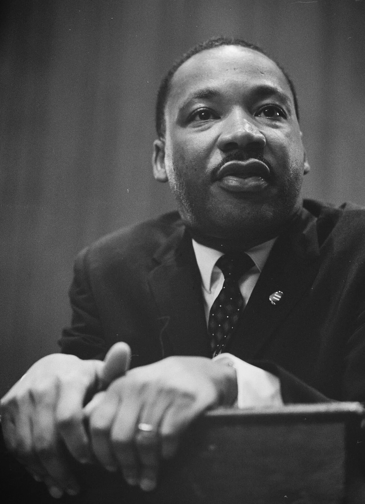 Martin Luther King Jr. leaning on a lectern in 1964