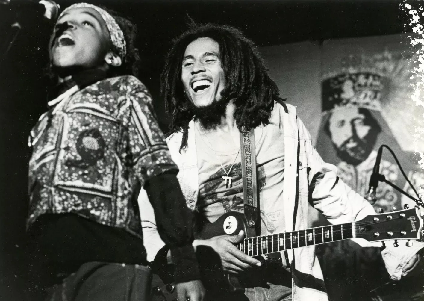 Bob Marley 1976 lachend mit Gitarre auf der Bühne